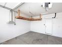 Uncluttered garage with overhead storage space, clean epoxy floor, and bright lighting at 16418 W Whitehorn Way, Surprise, AZ 85387