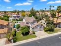 Aerial view of a home with three-car garage, landscaped yard, private pool, and surrounded by lush greenery at 19920 N 69Th Ave, Glendale, AZ 85308