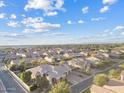A high-altitude aerial shot capturing the expansive neighborhood with blue skies and scattered clouds at 21912 E Desert Hills Dr, Queen Creek, AZ 85142