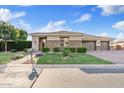 Beautiful home with well-manicured lawn, lush landscaping, and a three car garage at 21912 E Desert Hills Dr, Queen Creek, AZ 85142