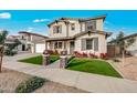 Two-story home featuring manicured lawn, stone pillars, and a welcoming front porch with wood supports at 22870 E Sonoqui Blvd, Queen Creek, AZ 85142