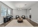 Spacious living room with hardwood floors, neutral walls, piano, modern furnishings, and natural light at 22870 E Sonoqui Blvd, Queen Creek, AZ 85142