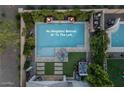 Aerial view of a backyard oasis featuring a sparkling pool, lush landscaping, and a private patio area, with no neighbors behind at 2339 E Questa Dr, Phoenix, AZ 85024