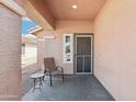 Covered front porch features a chair and small table, offering a cozy outdoor relaxation space at 2401 E Antigua Dr, Casa Grande, AZ 85194