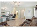 Open-concept living room featuring tile floors, a ceiling fan, and a comfortable leather sofa at 2401 E Antigua Dr, Casa Grande, AZ 85194