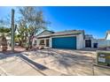 Inviting single-story home with desert landscaping and a striking blue garage door for added curb appeal at 2421 E Dragoon Ave, Mesa, AZ 85204