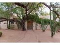 Inviting front entrance with a rustic wooden door, lush greenery, and desert landscaping at 2430 N 56Th St, Phoenix, AZ 85008