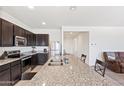 Kitchen island featuring granite countertops, stainless steel appliances, and dark cabinets at 24559 W Flores Dr, Buckeye, AZ 85326
