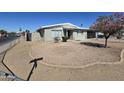 Charming single-story home featuring a xeriscaped yard, gray paint, and a black garage door at 2544 N 52Nd Ave, Phoenix, AZ 85035