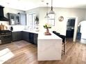 Bright, modern kitchen featuring a waterfall island, gray cabinetry, and stainless steel appliances at 2707 E James St, Gilbert, AZ 85296
