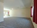 Bright living room with neutral carpet and access to the patio; window with red curtain at 2826 E Tracy Ln # 3, Phoenix, AZ 85032