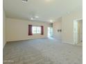 Spacious living room featuring neutral carpet, ceiling fan, and a view of the entry and hallway at 2826 E Tracy Ln # 3, Phoenix, AZ 85032