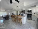 The kitchen features white cabinets, stainless steel appliances, an island, and adjoins the laundry room at 3738 W Danbury Dr, Glendale, AZ 85308