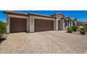 Attractive home with a three car garage, desert landscaping, and a paved driveway at 40470 W Agave Rd, Maricopa, AZ 85138