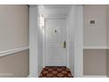 A white entrance door with decorative hardware inside a condo building, unit number 325 at 4200 N Miller Rd # 325, Scottsdale, AZ 85251