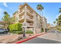 Beautiful multi-story condo with manicured landscaping, palm trees, and an attractive entryway at 4200 N Miller Rd # 325, Scottsdale, AZ 85251