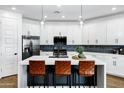 Modern kitchen with white cabinets, a center island with seating, and stainless steel appliances at 4543 S Nebula --, Mesa, AZ 85212