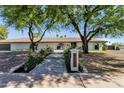 Inviting exterior view with a manicured walkway leading to the front entrance and lush landscaping at 5112 E Cholla St, Scottsdale, AZ 85254