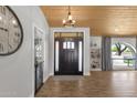 Bright foyer showcasing a wood-look tile floor, a modern light fixture, and an elegant front door at 5112 E Cholla St, Scottsdale, AZ 85254
