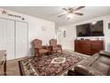 Cozy living room featuring hardwood furnishings, a ceiling fan, carpeted flooring, and a large television at 630 E Jensen St # 154, Mesa, AZ 85203
