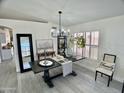 A dining room featuring wood-look tile, a modern chandelier, and decorative tables at 6626 W Monona Dr, Glendale, AZ 85308