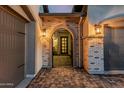 Charming entryway with brickwork, an arched doorway, and decorative lighting, leads to a stylish front door at 8127 E June St, Mesa, AZ 85207