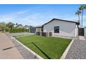 Charming home exterior showcasing a modern design, well-manicured artificial lawn, and striking curb appeal at 8430 E Fairmount Ave, Scottsdale, AZ 85251