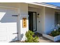 Charming home featuring a black front door with a wooden address plate and a white brick exterior at 864 W Monte Ave, Mesa, AZ 85210