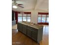 Open concept kitchen with an island that has granite countertops and gray painted cabinets at 9427 E University Dr # 48, Mesa, AZ 85207