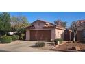 Charming single-Gathering home featuring a tile roof, brown garage door, desert landscaping, and a private, gated side entrance at 9967 W Devonshire Ave, Phoenix, AZ 85037