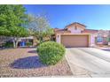 Single-story house featuring desert landscaping, a two-car garage, and mature trees for added curb appeal at 9967 W Devonshire Ave, Phoenix, AZ 85037