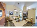 Bright living room with high ceilings, fireplace, and large windows offering natural light at 9967 W Devonshire Ave, Phoenix, AZ 85037