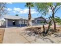 Attractive home featuring desert landscaping, covered parking, and gray brick accenting the facade at 1027 S Lola Ln, Tempe, AZ 85281