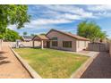 Spacious backyard with lush lawn, covered patio, play structure, and block fence at 1028 W Chilton Ave, Gilbert, AZ 85233