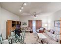 A large living room with multiple sofas, a glass top dining table, and a sliding door to the outside at 10401 W Loma Blanca Dr, Sun City, AZ 85351