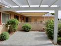 Private back patio with a pergola and decorative brick wall and mature plants at 10428 W Camelot Cir, Sun City, AZ 85351