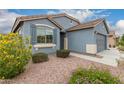 Inviting exterior with desert landscaping, shutters, and a neutral color scheme, offering a welcoming curb appeal at 18415 W Surprise Farms N Loop, Surprise, AZ 85388