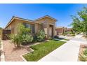 Landscaped home exterior featuring a lush lawn, desert accents, neutral paint, and well-maintained curb appeal at 22495 E Silver Creek Ln, Queen Creek, AZ 85142