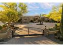 Beautiful home with a circular driveway, desert landscaping, and wrought iron gated entrance at 22610 N 80Th Pl, Scottsdale, AZ 85255