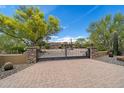 Beautiful home with a circular driveway, desert landscaping, and wrought iron gated entrance at 22610 N 80Th Pl, Scottsdale, AZ 85255
