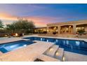 Inviting pool with baja step and travertine tile and outdoor seating area with fire pit at 22610 N 80Th Pl, Scottsdale, AZ 85255
