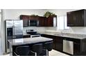 Modern kitchen featuring granite countertops, stainless steel appliances, and dark wood cabinets at 2745 W Jessica Ln, Phoenix, AZ 85041