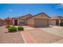 Charming home with desert landscaping, brick accents and a two car garage on a sunny day at 3035 W Roberta Dr, Phoenix, AZ 85083