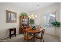 Traditional dining room with elegant chandelier, china cabinet, and round wood table at 3085 E Parkview Dr, Gilbert, AZ 85295