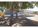 Charming single-story home with a covered parking area and mature trees at 319 S 90 Pl, Mesa, AZ 85208