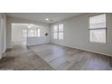 Bright living room featuring wood-look floors, neutral paint, archway, and natural light from multiple windows at 45633 W Mountain View Rd, Maricopa, AZ 85139