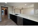 This updated kitchen features black cabinets, stainless appliances, and a large quartz countertop at 5221 N 24Th St # 103, Phoenix, AZ 85016