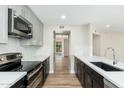 Modern kitchen with stainless steel appliances, sleek countertops, and view into other rooms at 5221 N 24Th St # 103, Phoenix, AZ 85016