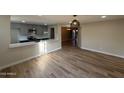 Open-concept living area featuring updated kitchen, wood flooring, and modern light fixture at 5221 N 24Th St # 103, Phoenix, AZ 85016