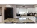 Updated kitchen features granite countertops, white cabinetry, and stainless steel appliances at 546 S Ellsworth Rd, Mesa, AZ 85208